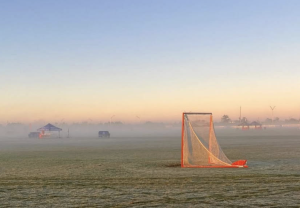 A lacrosse goal sits alone the morning of a club lacrosse tournament. Lacrosse goals are different from any other sports goal.