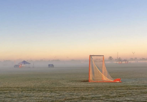 A lacrosse goal sits alone the morning of a club lacrosse tournament. Lacrosse goals are different from any other sports goal.