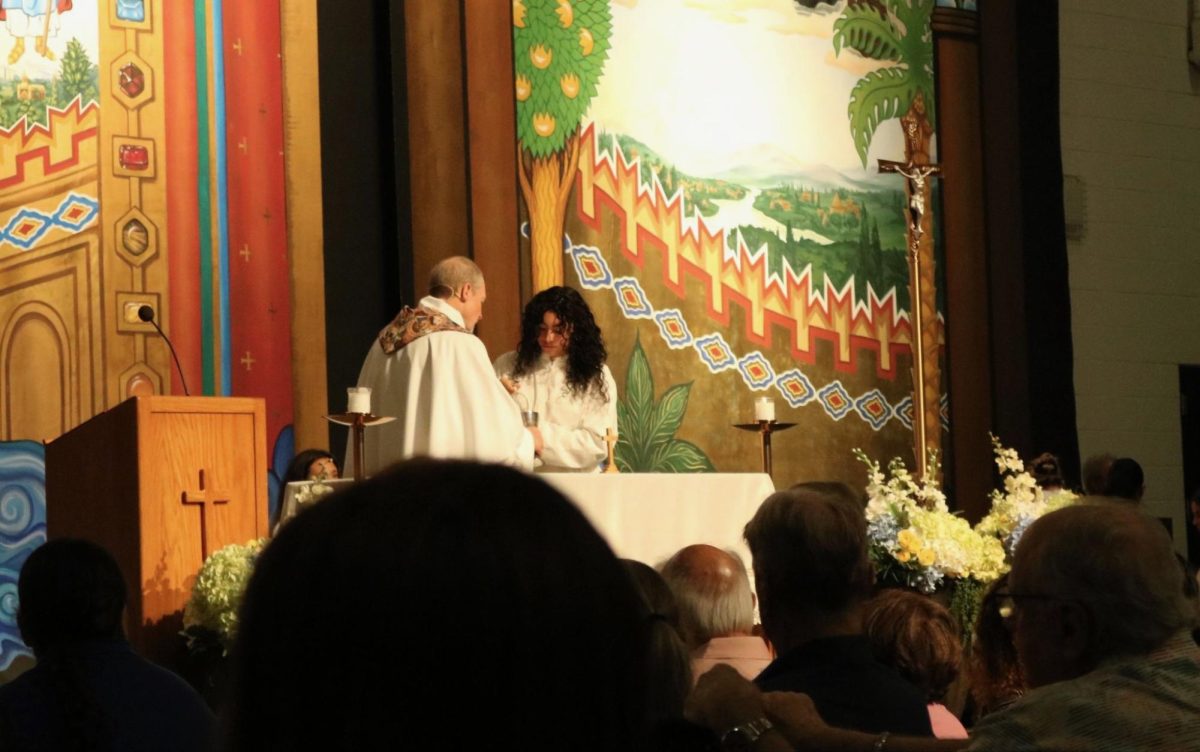 During the Grandparents Mass on Friday, Sept. 18, Father Chris Cartwright performs the act of purification after Holy Communion with altar server, Isabella Garcia ‘29. The Eucharistic ministers have just presented the body of Christ to students, staff and grandparents.