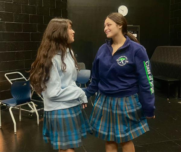 Isa Earl Castillo ‘28 (left) and Maddie Medina ‘28 (right) converse in The Brophy Black Box Theater before a rehearsal for the “Pride and Prejudice” production. The students were participating in a team-building exercise to prepare for their upcoming performances.
