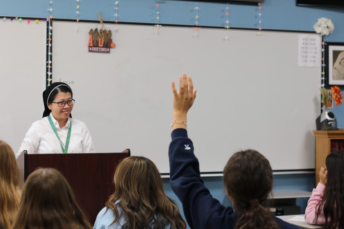 Sophomore theology teacher Sister Theresa Trang stands at the front of her class and teaches through interactive learning. By having students take notes, Trang keeps the girls prepared for upcoming tests and quizzes.